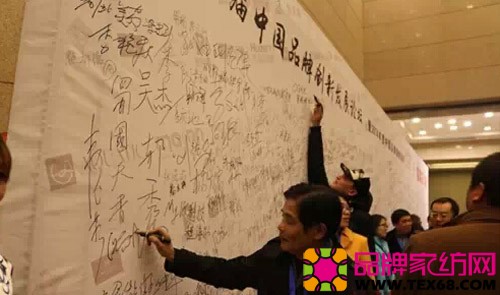 越龙家纺董事长汝兴龙在荣誉墙上签字