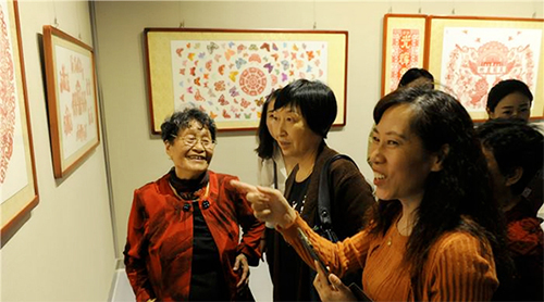 王德荣老人（左一）在个人剪纸作品展览会上